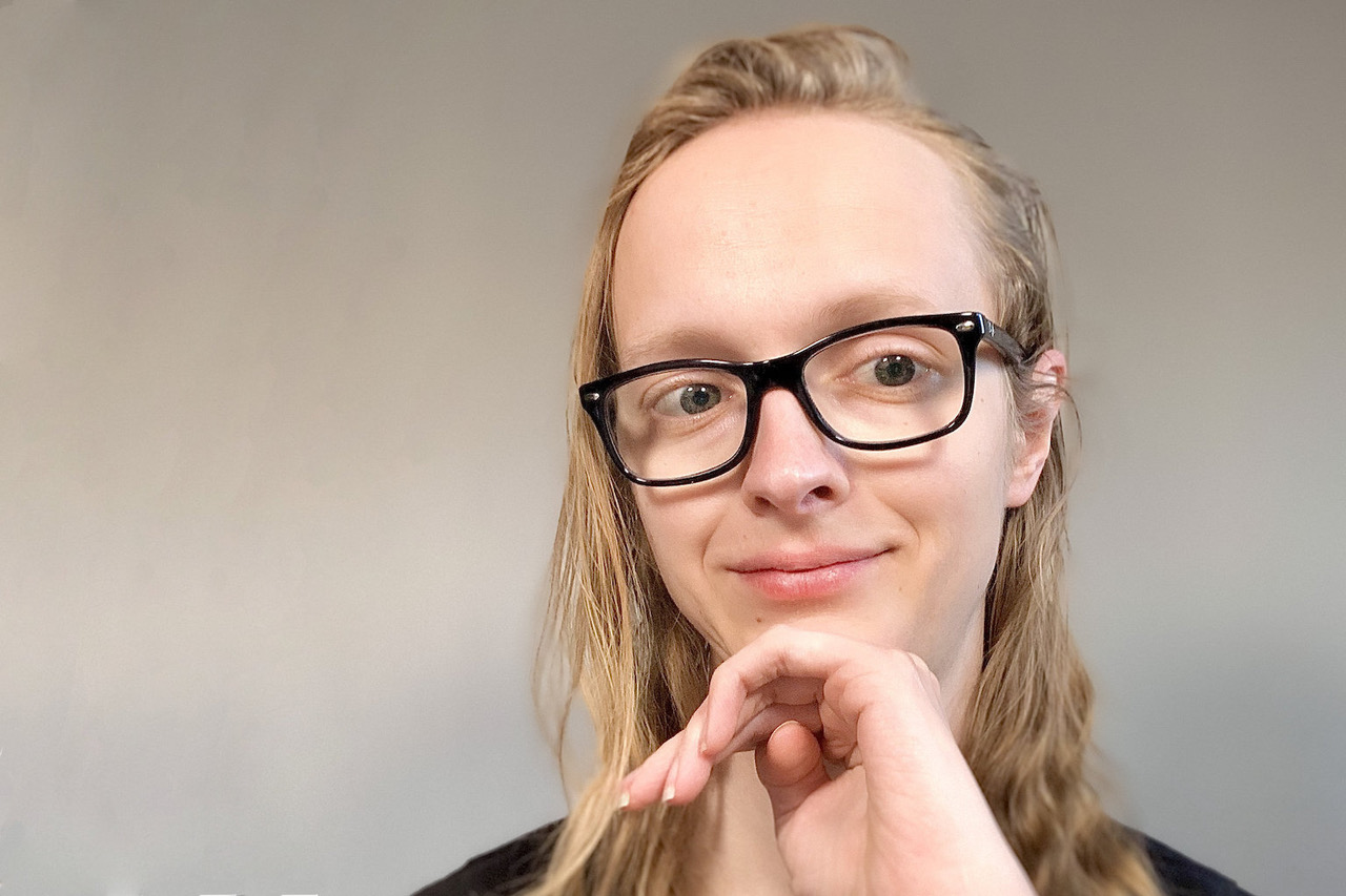 Headshot of Bianca Kastl. Bianca has light blonde long hear and wears it openly. She has light skin and wears glasses with a black frame. Her head rests on her left hand, she smiles and looks slightly to the side of the camera.