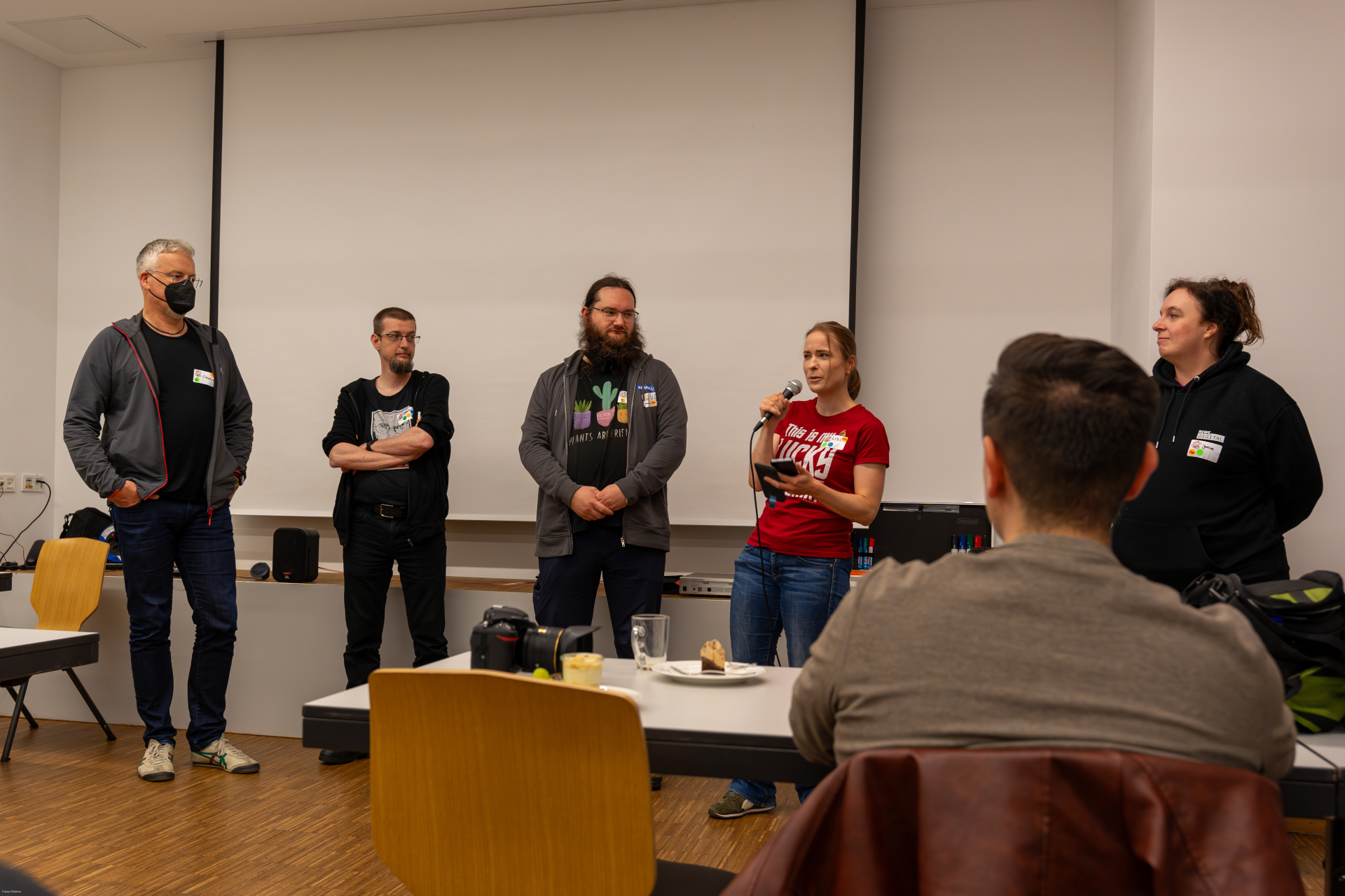 Organization Team The organization team of the osco 2024. Claudius, Dave, Uli, Lissi and Janina. A photo of the five in front of the audience.